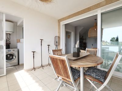 Terrace featuring a round wooden table and matching chairs, with access to a laundry room.