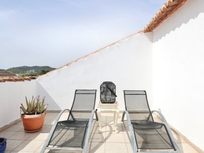 Terrace featuring two metal sun loungers, side table, and mountain views.