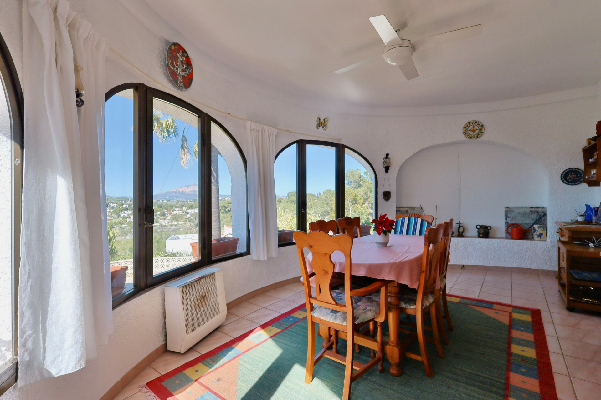 Bright dining room featuring arched windows with panoramic views of the Jávea landscape.