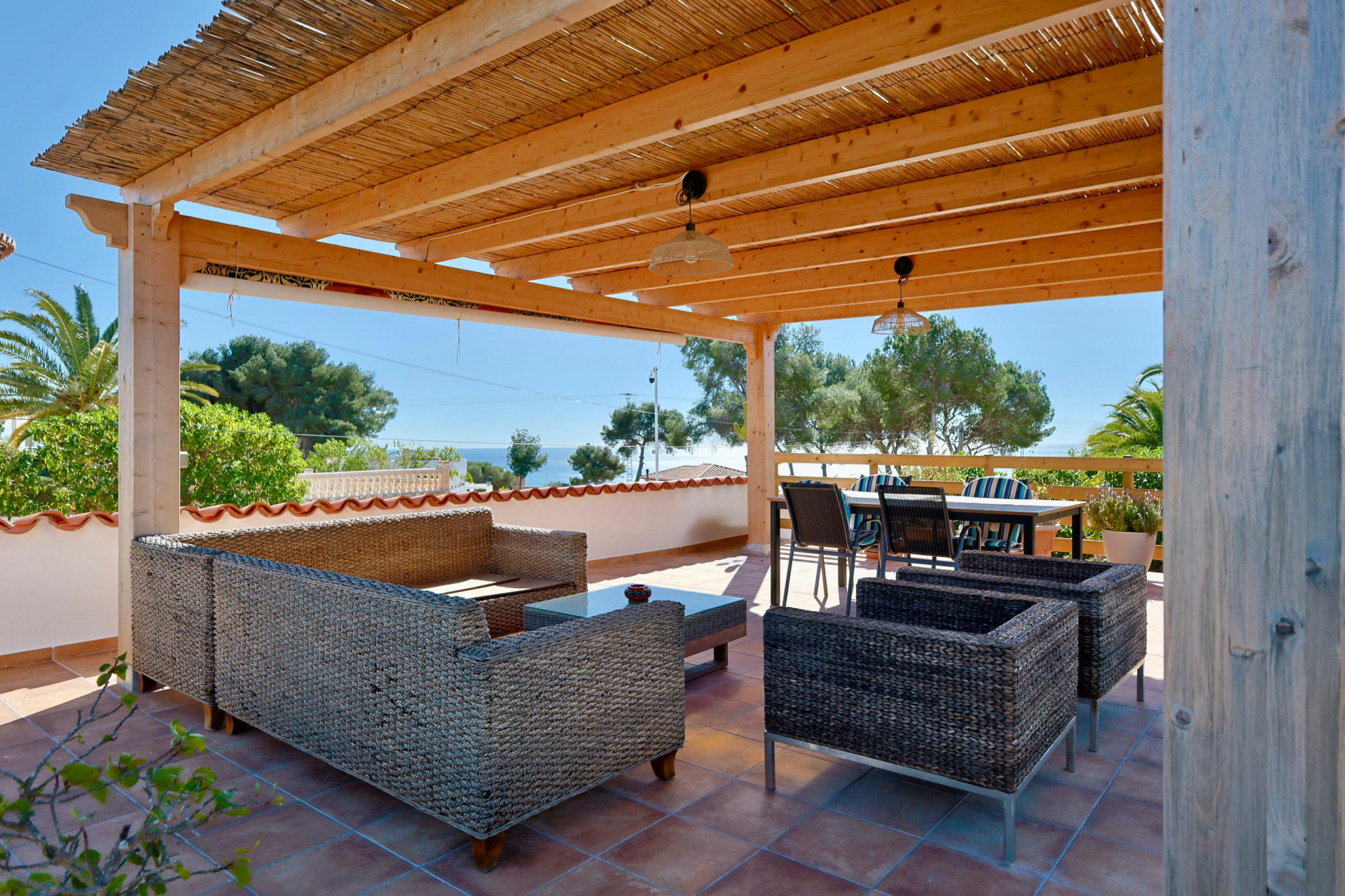 Covered terrace featuring rattan furniture and sea views.
