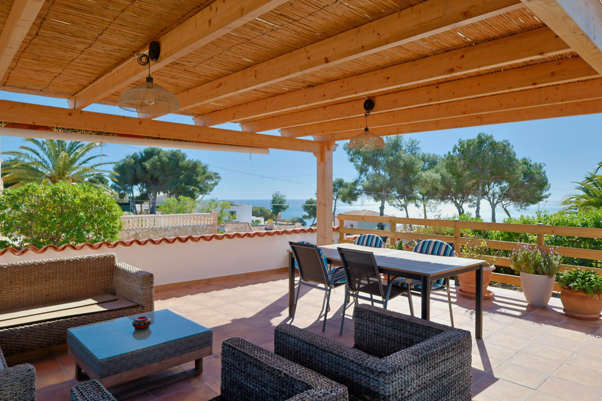 Covered terrace with sea views and rattan furniture.