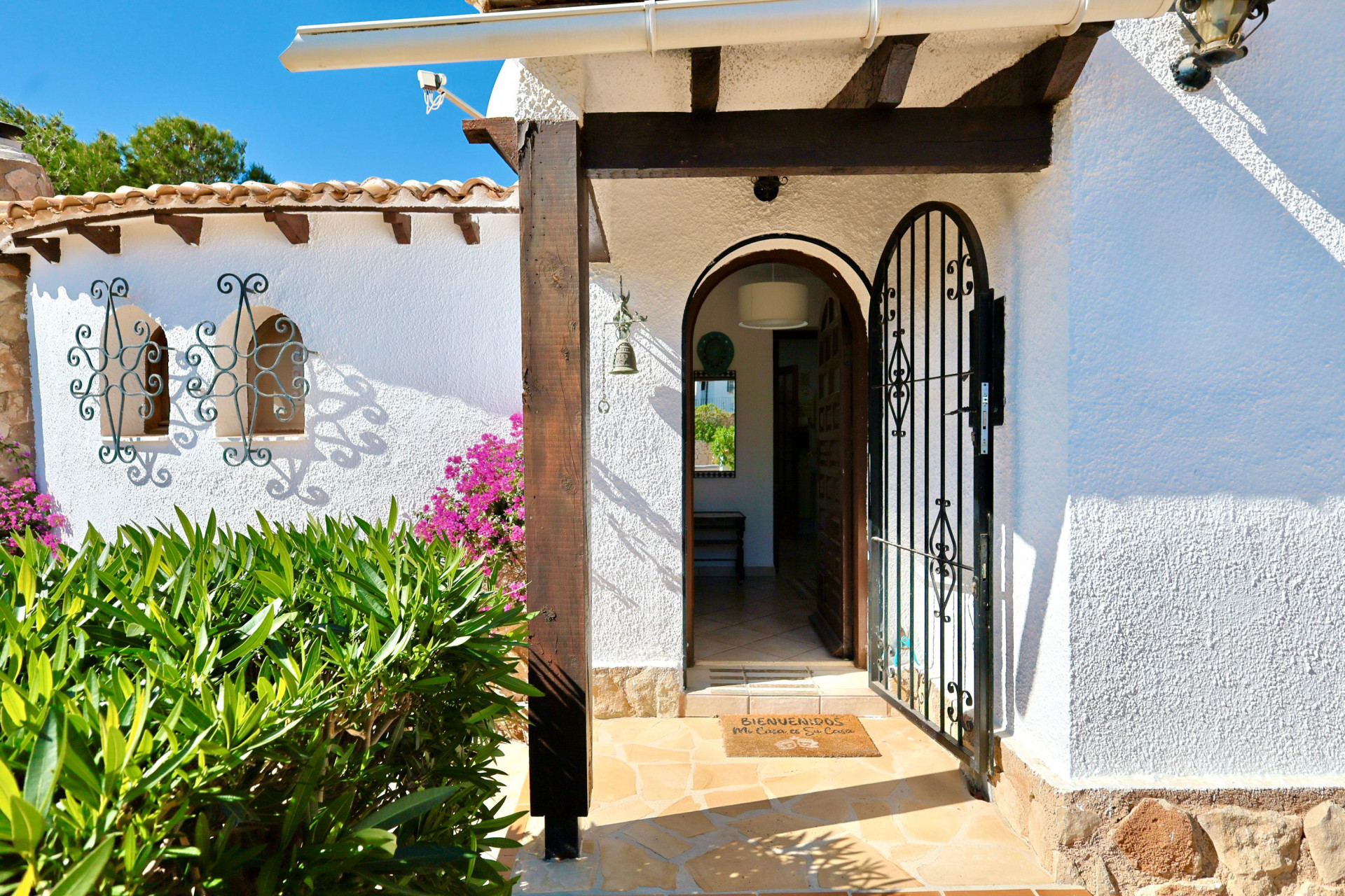 Main entrance featuring a wrought iron gate and a welcome mat.