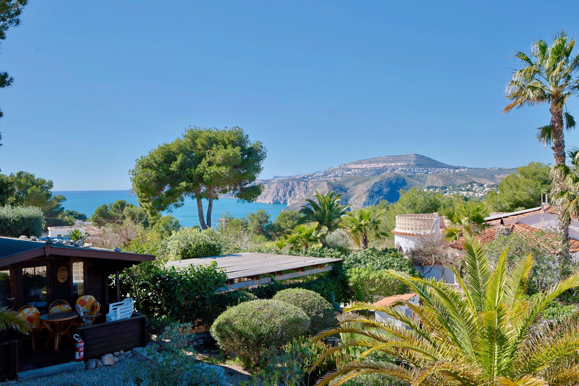 Panoramic view of Jávea featuring a wooden cabin and lush greenery.