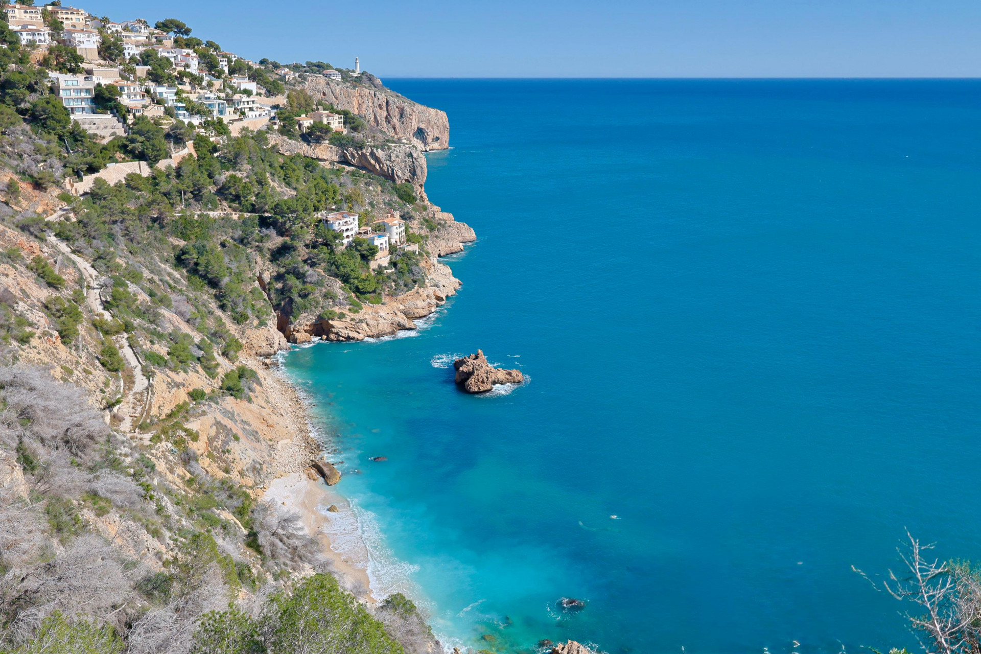 Panoramic view of Jávea's rocky coastline and turquoise waters.