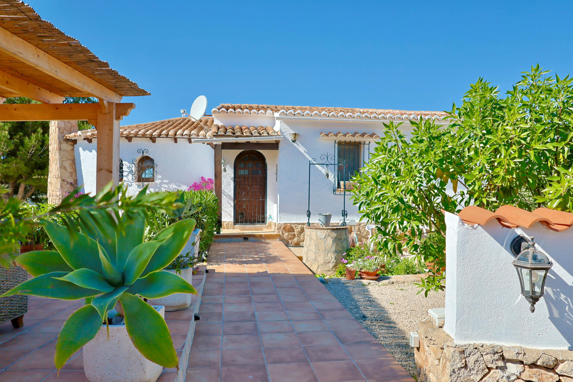 View of the main entrance featuring a stone well and tiled pathway.
