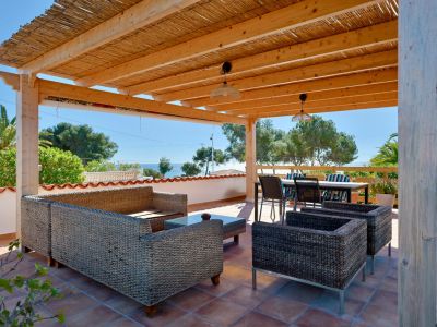 Covered terrace featuring rattan furniture and sea views.