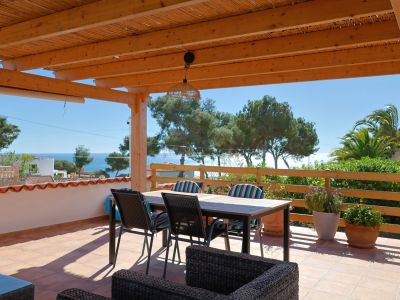 Covered terrace featuring sea views and dining furniture.