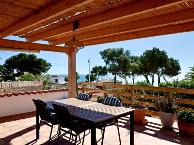 Covered terrace with dining table and sea views in Jávea.