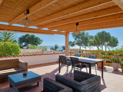 Covered terrace with sea views and rattan furniture.