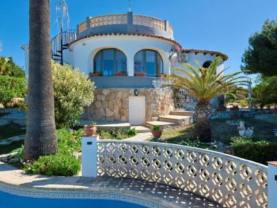 Exterior view of the villa with pool and stone facade, surrounded by Mediterranean gardens.