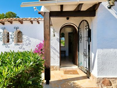 Main entrance featuring a wrought iron gate and a welcome mat.