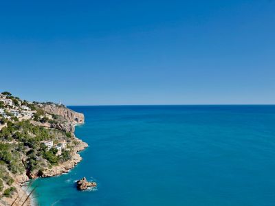 Panoramic view of Jávea's rocky coastline and the blue Mediterranean Sea.