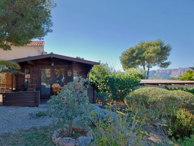 View of the wooden cabin, featuring a Mediterranean garden and sea views in Jávea.