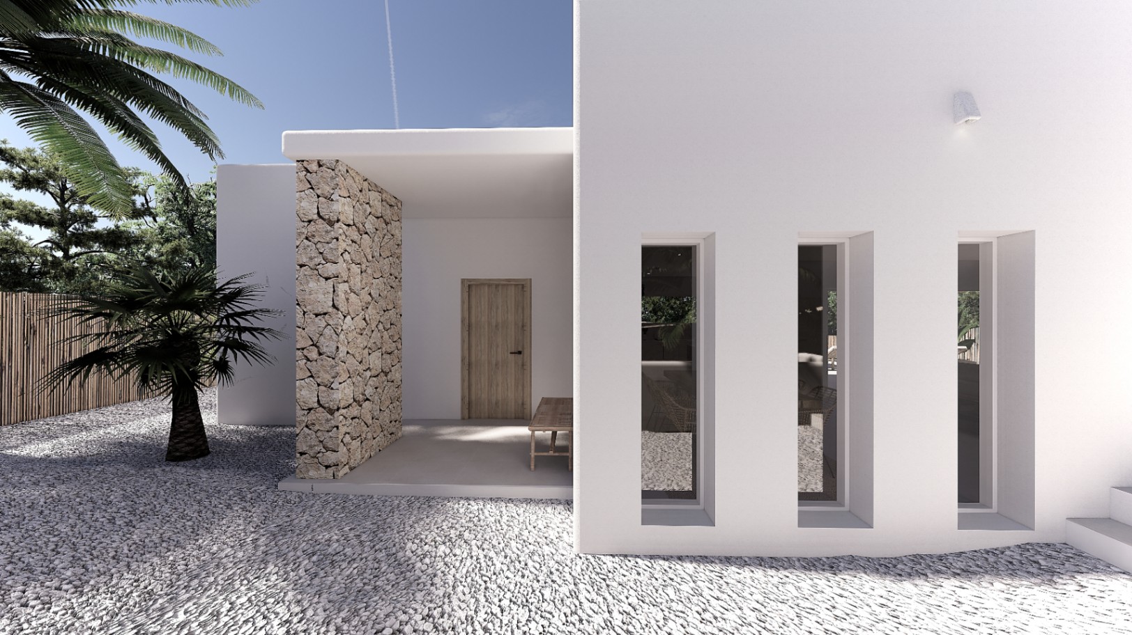 Main entrance featuring a white minimalist facade, natural stone wall, and vertical slit windows. The approach is finished with white gravel and Mediterranean landscaping.
