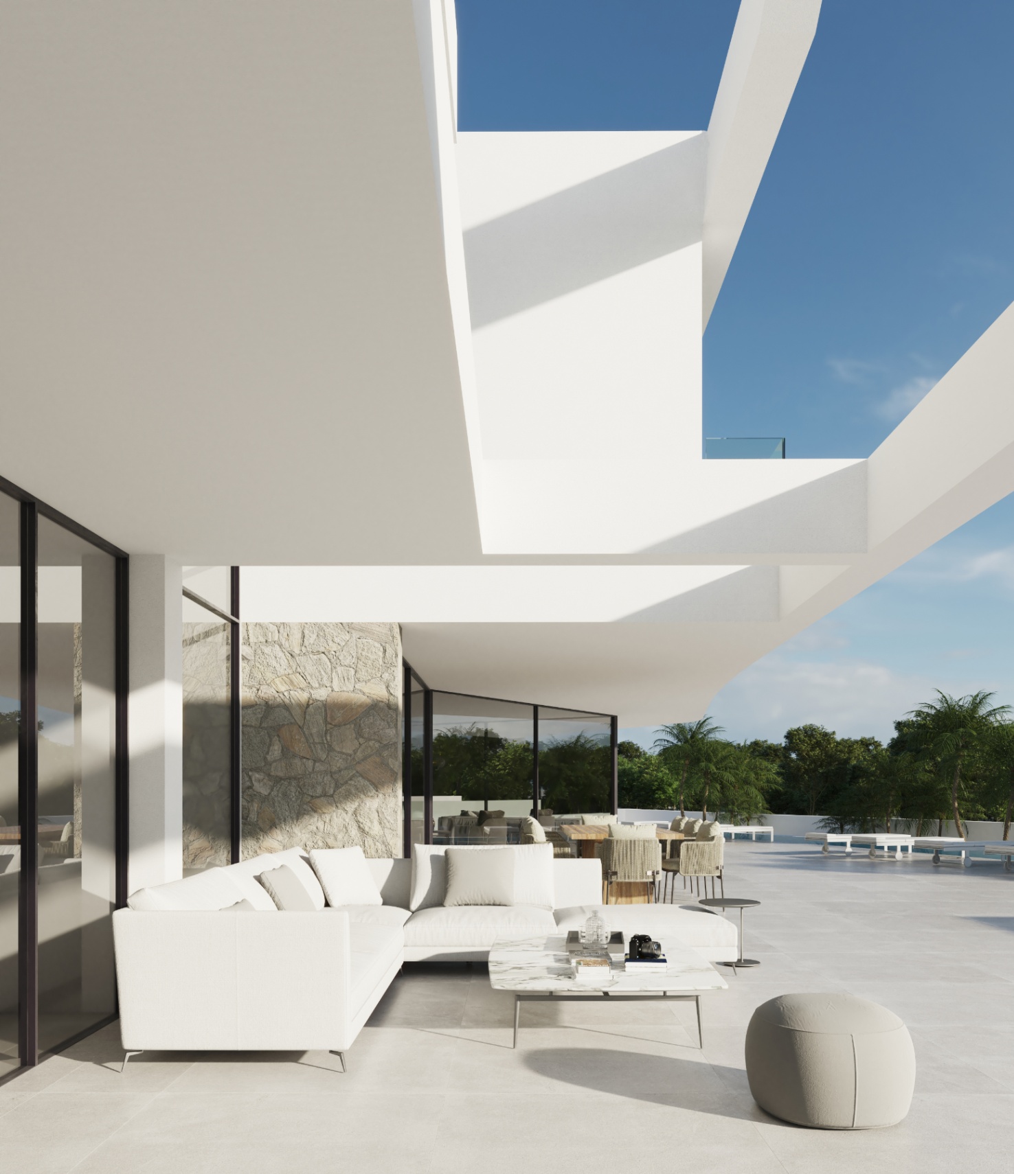 Main terrace featuring an outdoor lounge with designer sofas and natural stone accents under a modern white cantilevered architectural structure.