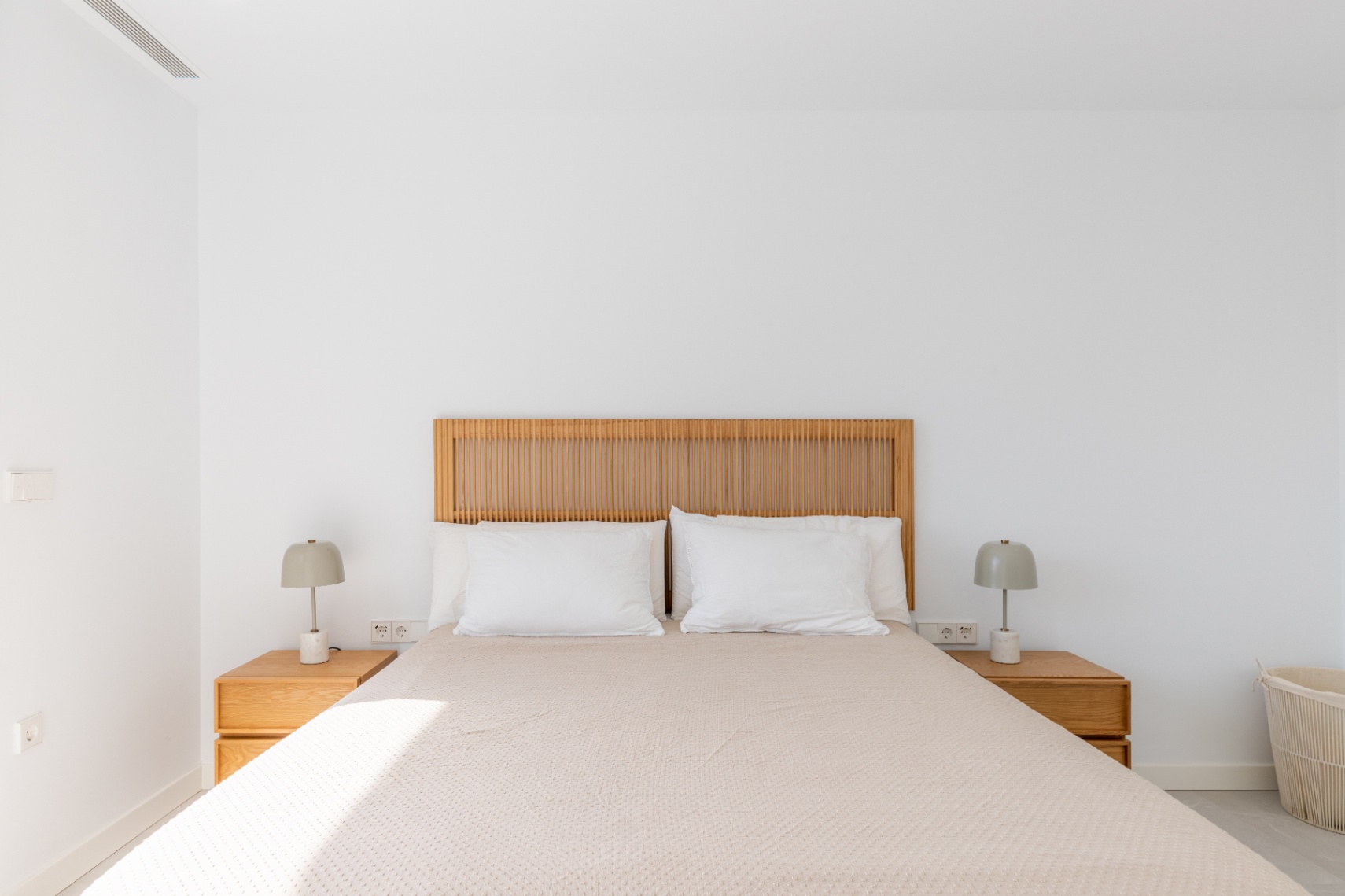 Bright bedroom featuring a wooden headboard and matching nightstands.