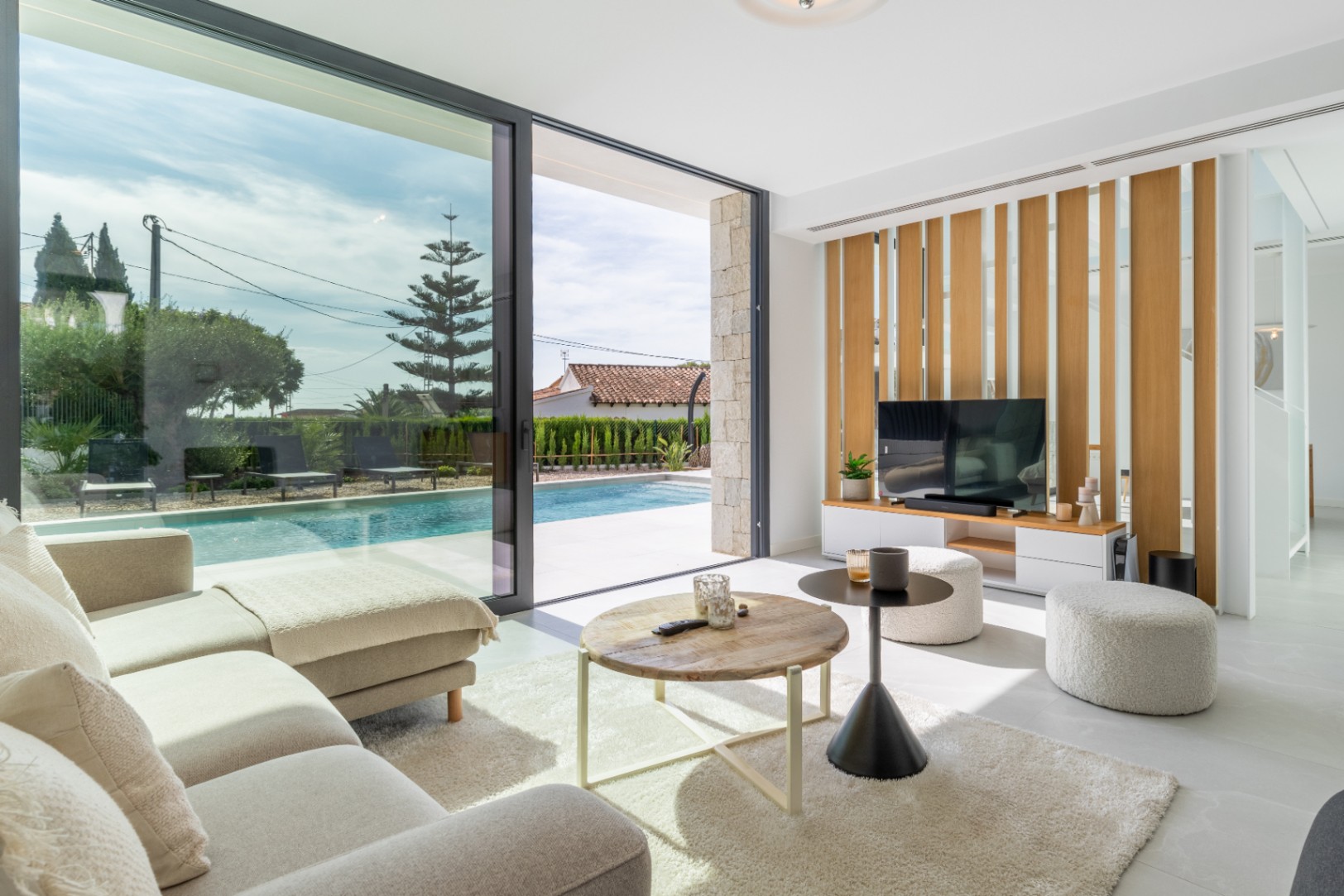Bright living room with pool access and decorative wood slat wall.