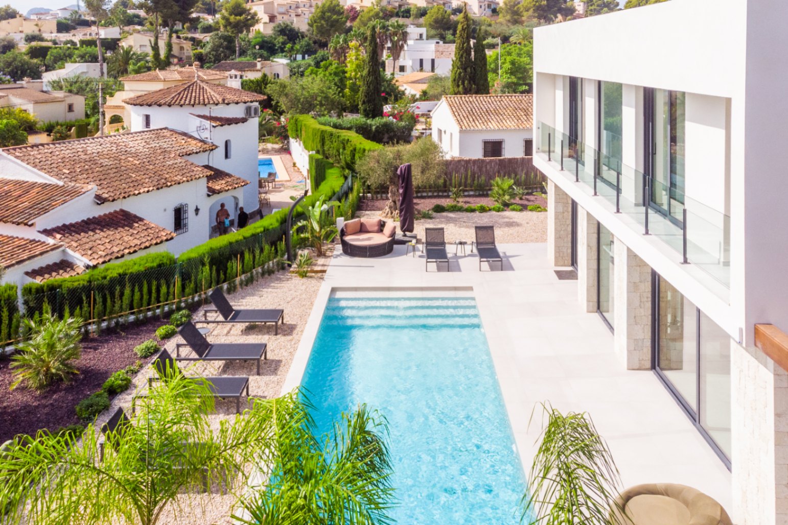 Elevated view of the rectangular pool with black sun loungers and gravel garden.