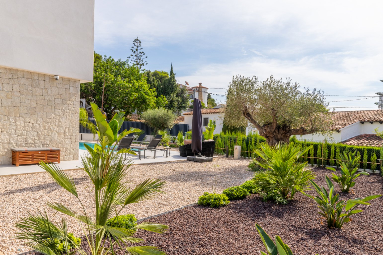 Mediterranean garden with gravel, pool and sun loungers in La Fustera, Benissa.