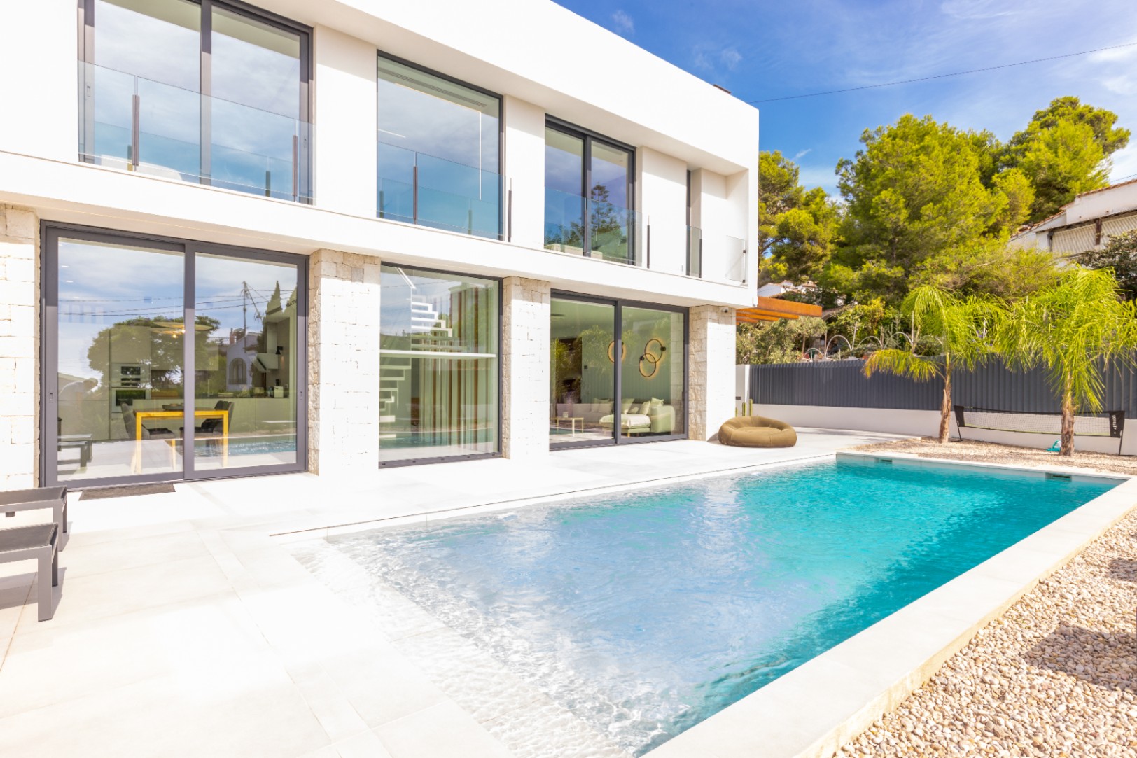 View of the private pool, tiled terrace, and modern facade of the villa in Benissa.