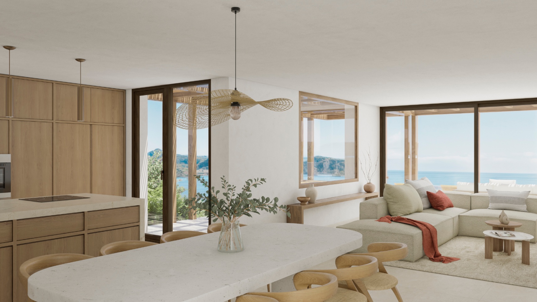 Bright interior featuring an open kitchen, stone island, and ocean views.