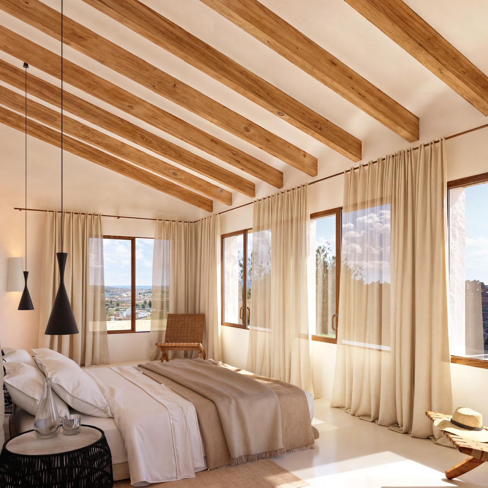Bedroom featuring exposed wooden ceiling beams, large timber-framed windows, and natural light showcasing panoramic views of the coast.