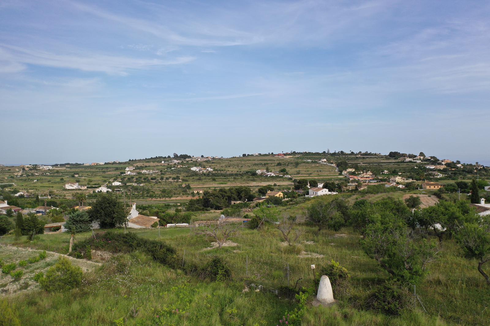 Panoramic view of the natural surroundings featuring terraced hills and indigenous Mediterranean vegetation under a clear sky.