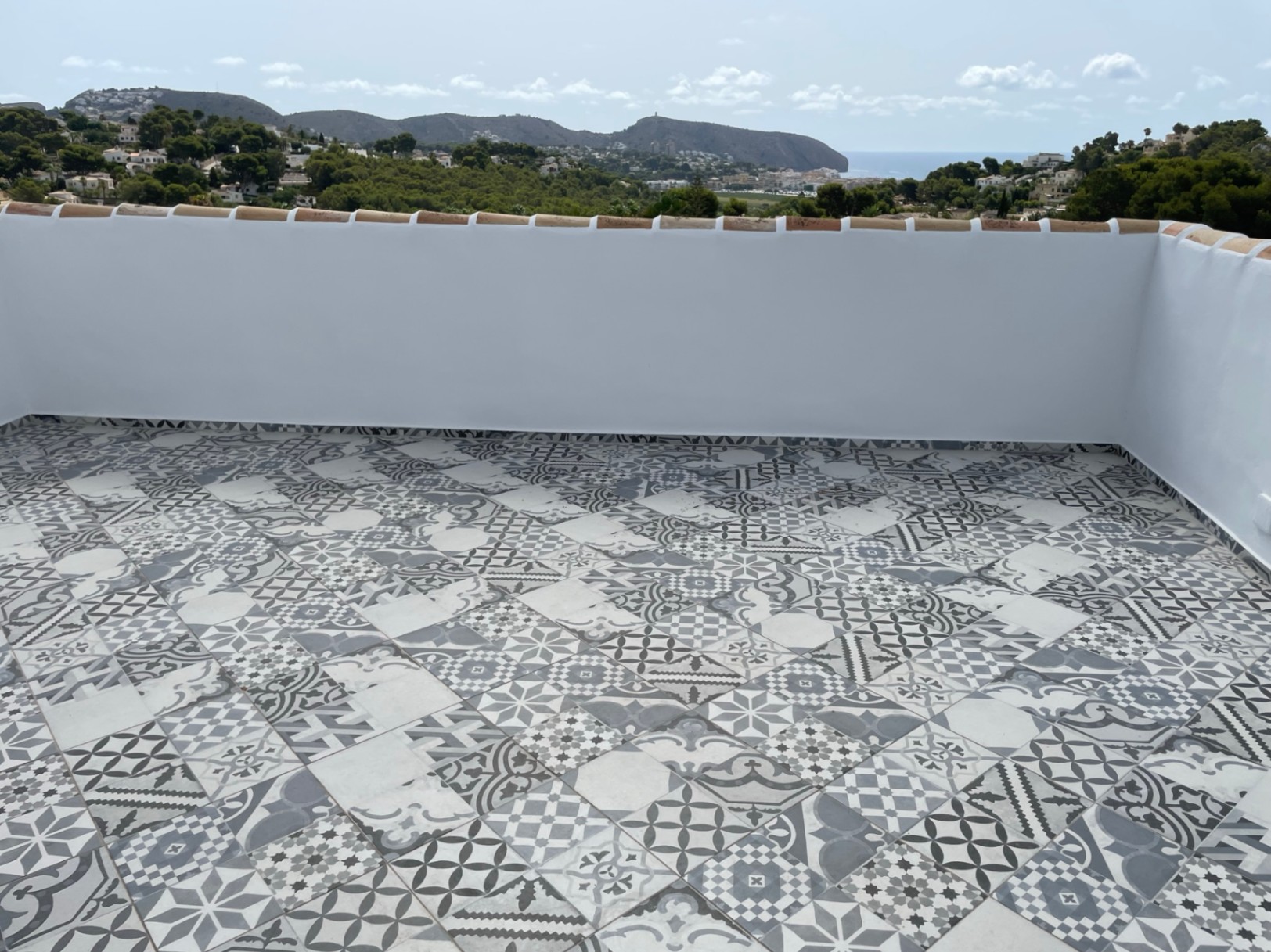 Rooftop solarium featuring decorative patterned tiles and panoramic views of the Mediterranean Sea and the Moraira coastline.