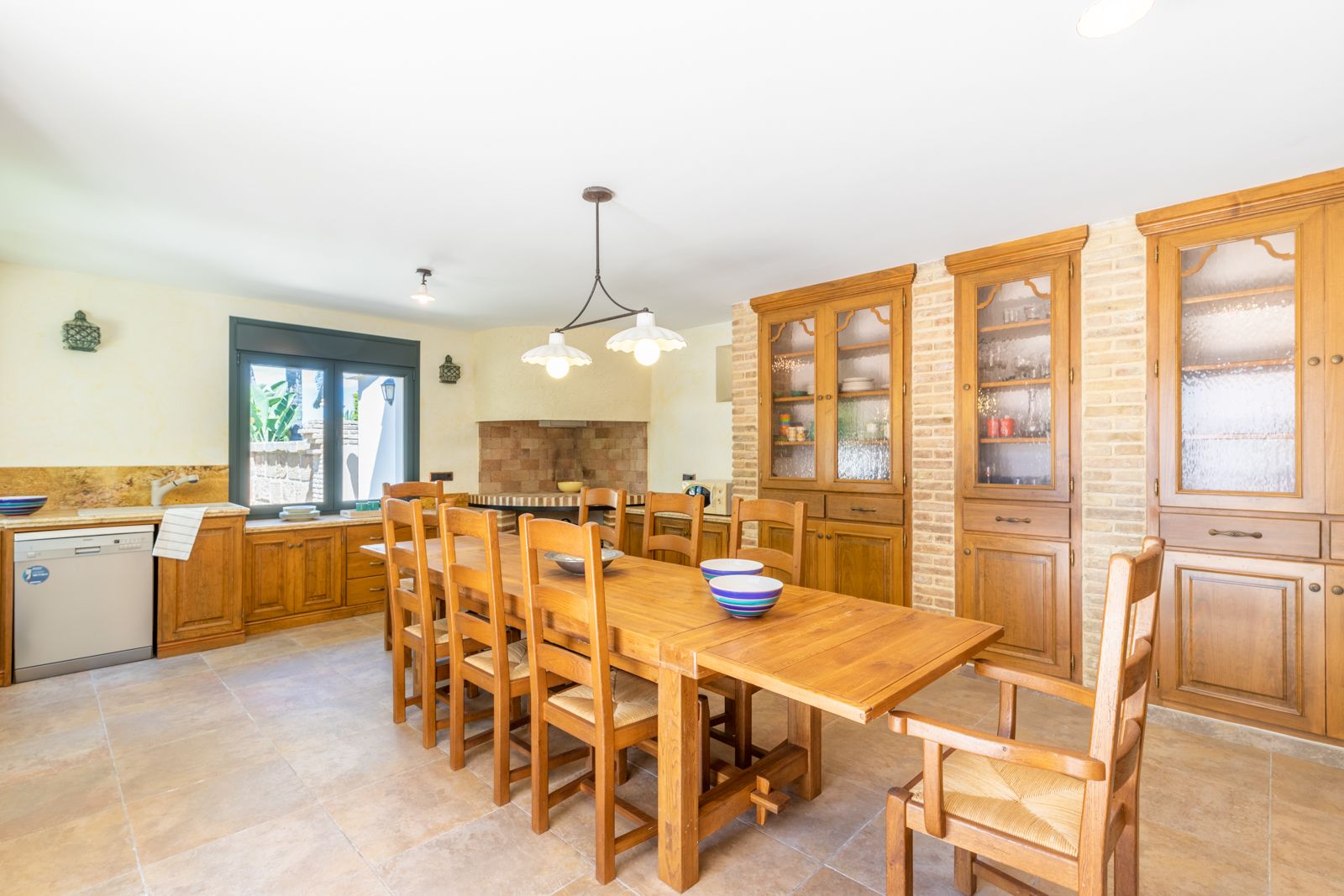 Dining room featuring a solid wood table and a built-in hutch with exposed brick.