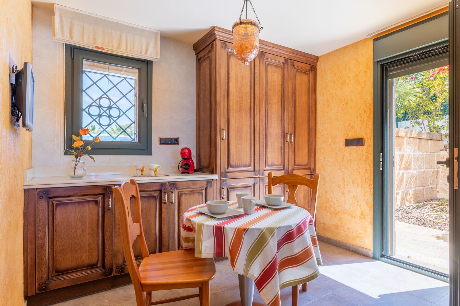 Rustic kitchen featuring a covered round table and dark wood cabinets.