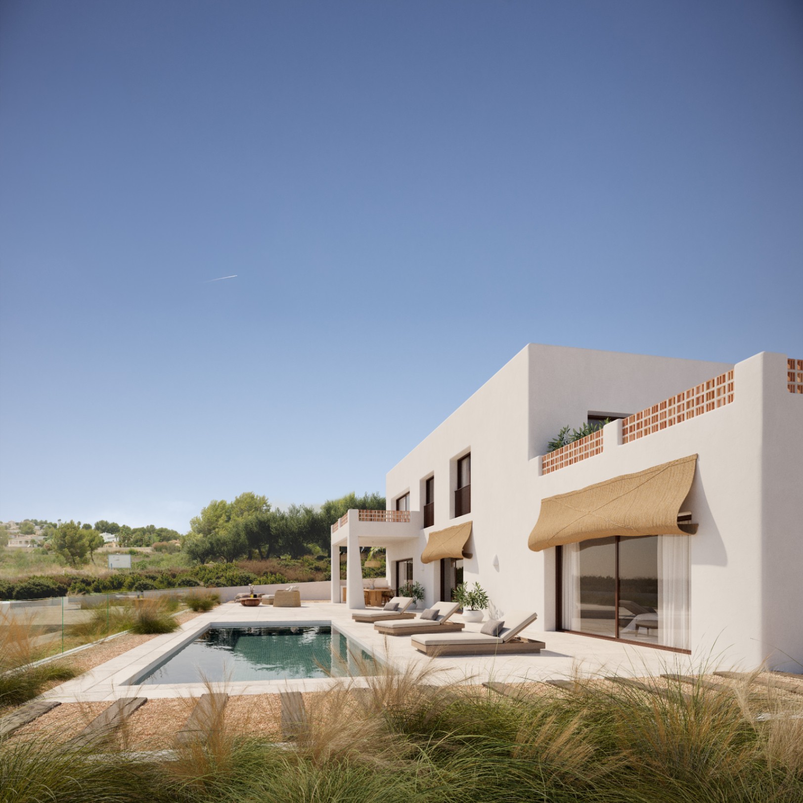 Exterior view featuring a rectangular swimming pool, stone terrace, and natural fiber awnings. The white facade includes terracotta lattice accents and large glass doors.
