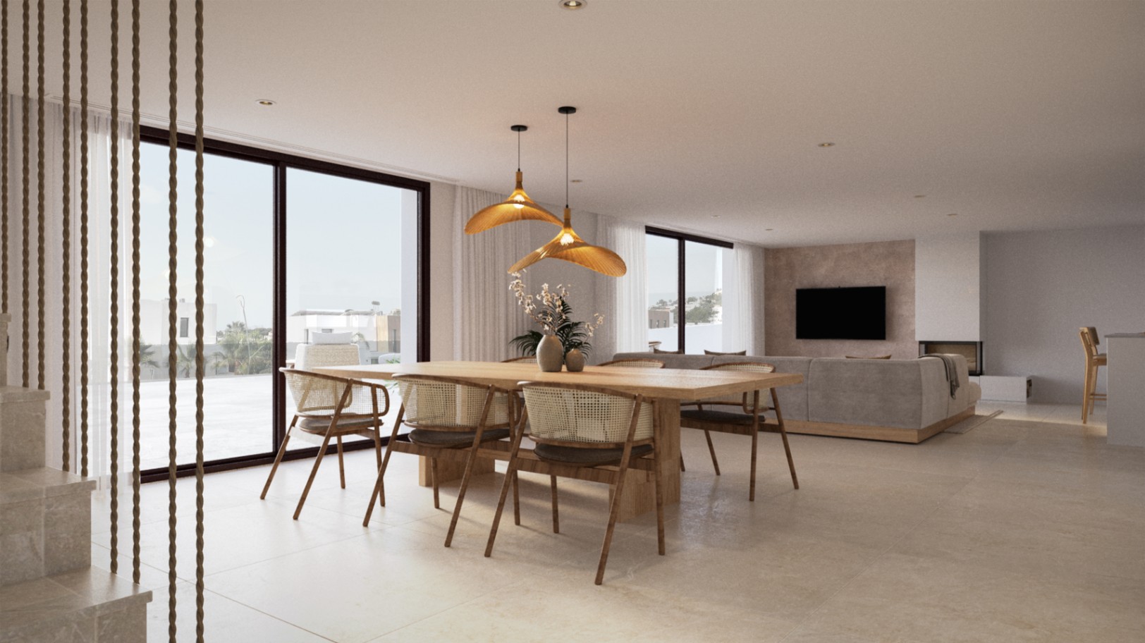 Open-plan living and dining area featuring a solid wood table, rattan chairs, and organic pendant lighting. Large sliding glass doors provide seamless access to the terrace.