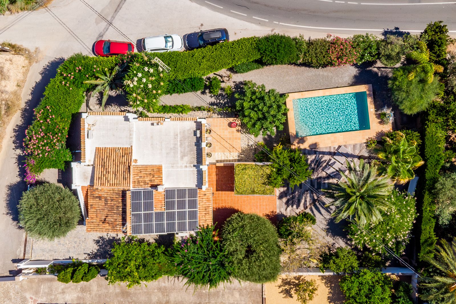 Aerial top-down view showcasing the 918 m² plot layout, featuring the private pool, rooftop solar panel installation, and mature Mediterranean landscaping.