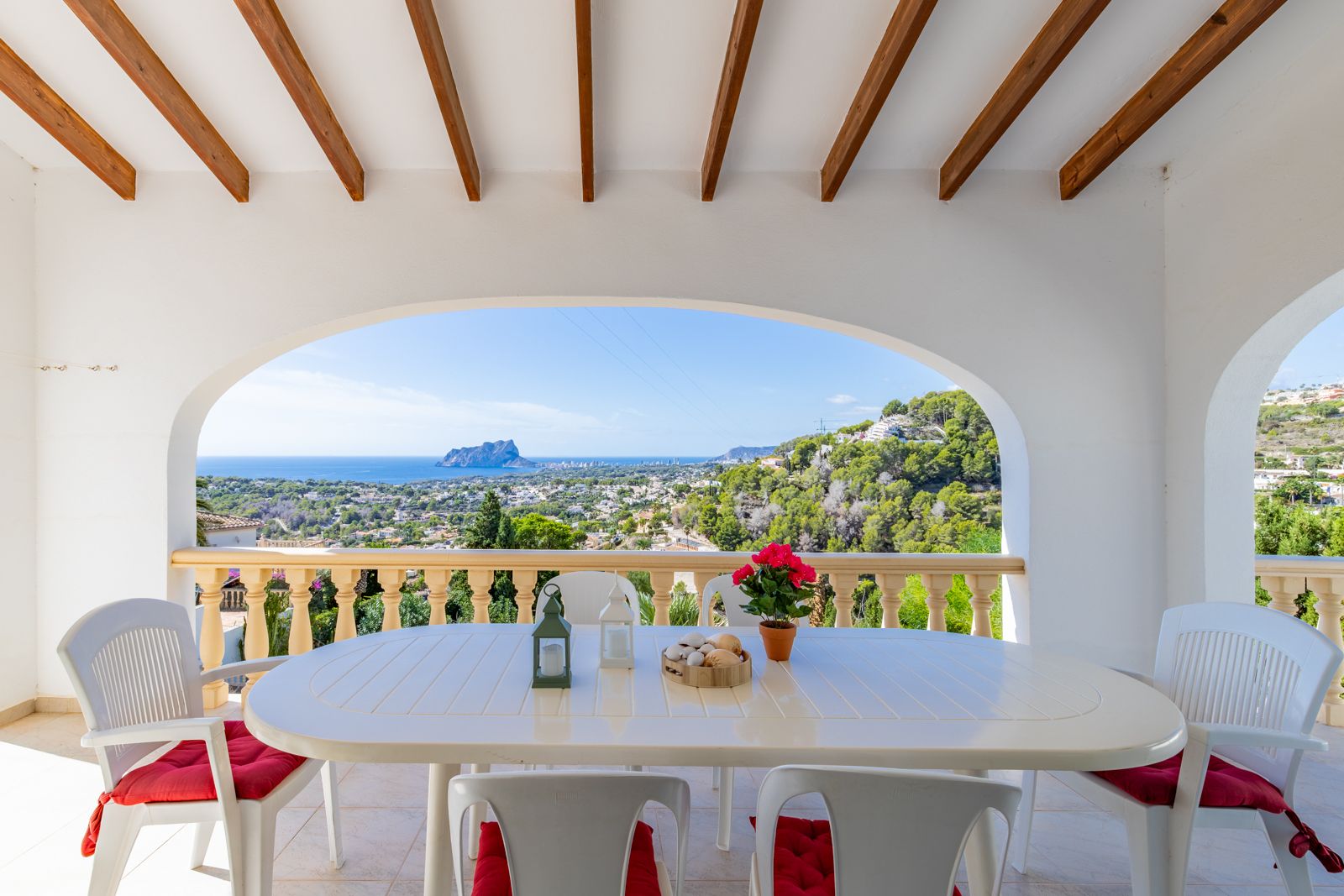 Covered terrace featuring traditional wooden beams and arched openings, providing panoramic views of the Mediterranean Sea and Peñón de Ifach.
