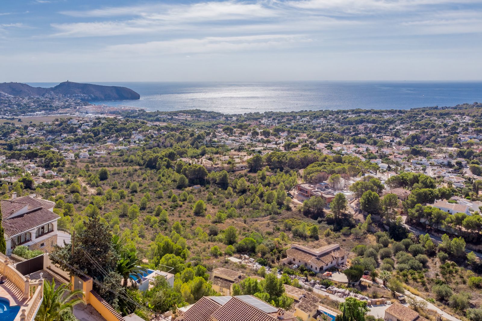 Panoramic views of the Mediterranean Sea and Cap d'Or from Benimeit, showcasing the lush coastal landscape and Moraira's shoreline under bright daylight.