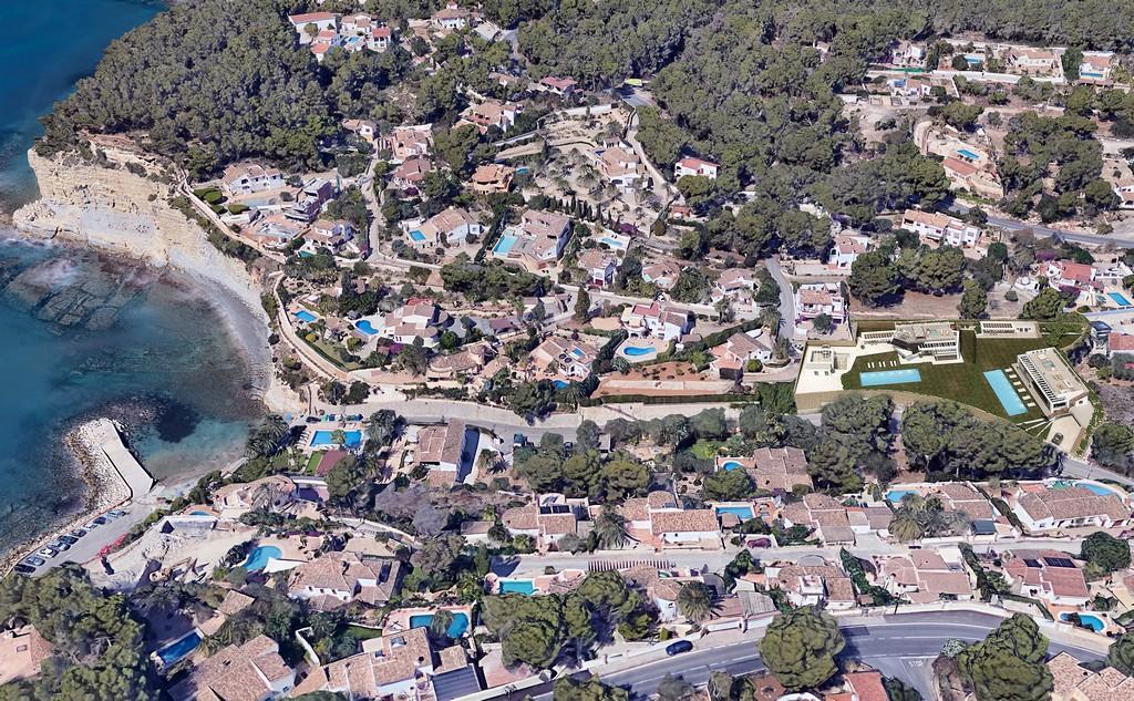 Aerial view illustrating the plots' proximity to Cala Advocat, featuring modern villa renders with private pools just 150 meters from the Mediterranean shoreline.