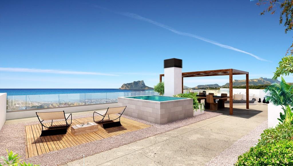 Rooftop solarium featuring an elevated pool, wooden pergola dining area, and panoramic views of the Mediterranean Sea and Peñón de Ifach.