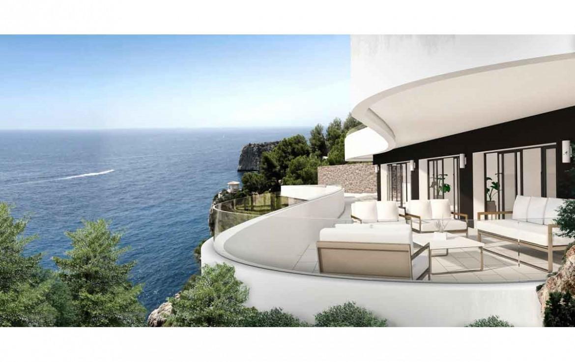 Curved terrace featuring glass railings and modern outdoor seating, overlooking the Mediterranean Sea and coastal cliffs in Jávea.