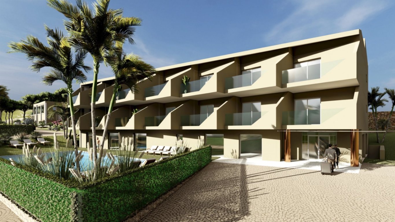 Exterior view of the three-story boutique hotel featuring private balconies with glass railings, a swimming pool area with sun loungers, and a cobblestone entrance.