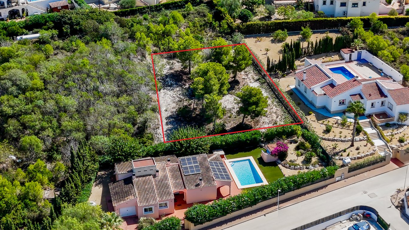 Aerial view showing the villa with solar panels and pool, alongside the adjacent urban plot with mature pine trees, highlighted in red.