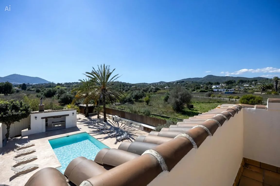 Elevated view from the upper level overlooking the 5x10m swimming pool, outdoor kitchen, and expansive countryside views towards the mountains.