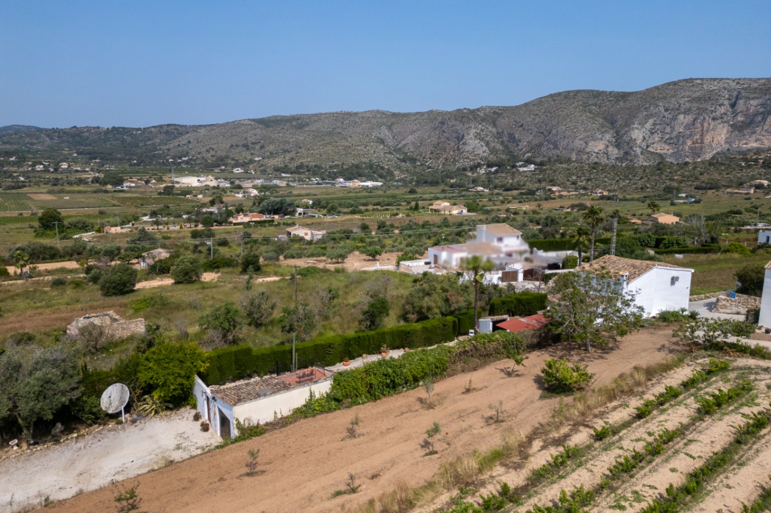 Aerial view of the Teulada estate with cultivated land and white building.