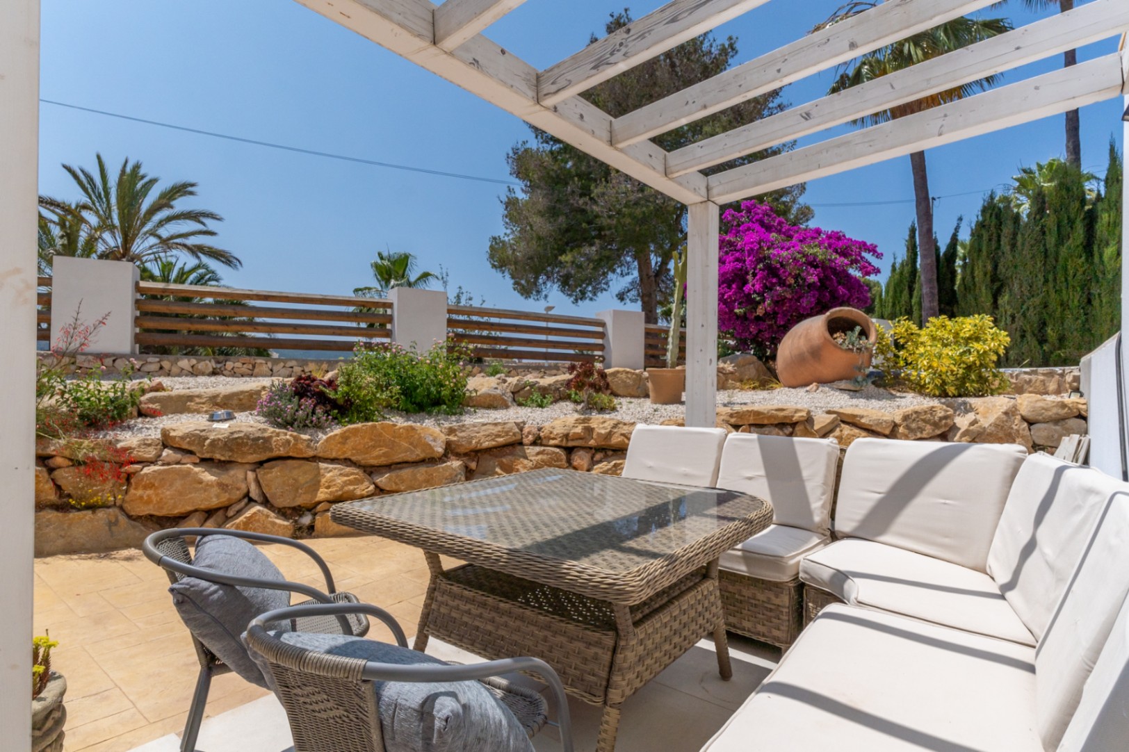 Covered terrace with a view of the rock garden and fuchsia bougainvillea.