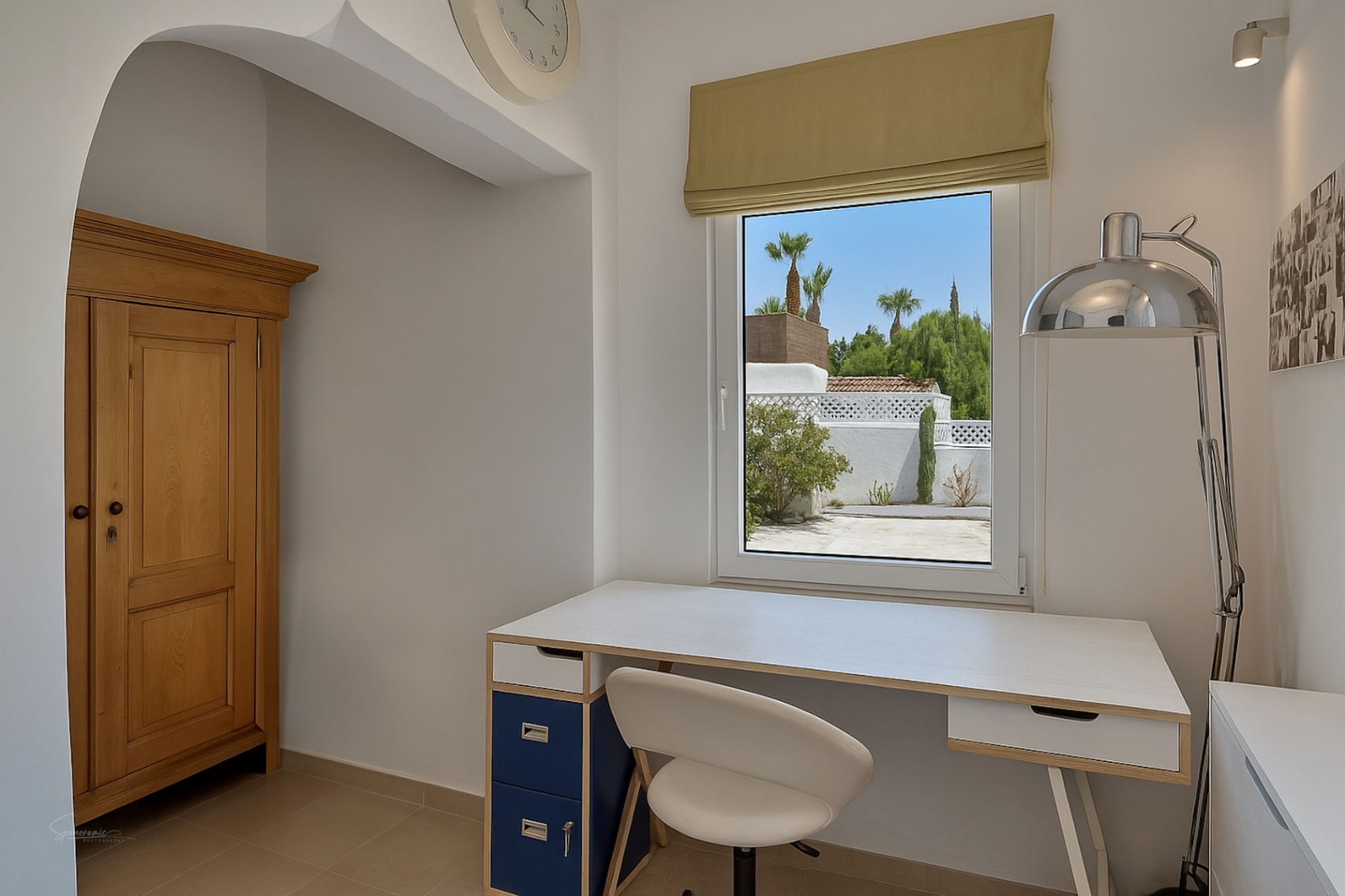 Office detail with white desk, wooden cabinet, and exterior views.