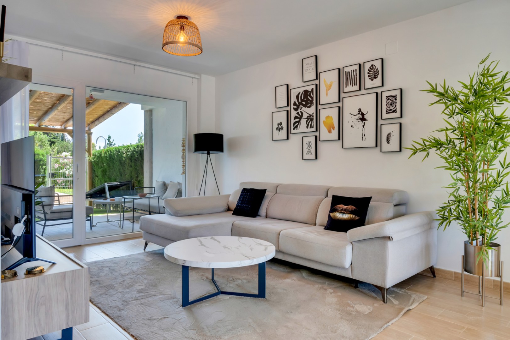 Open-concept living area featuring a modern sectional sofa, marble coffee table, and large sliding doors leading to the private patio.