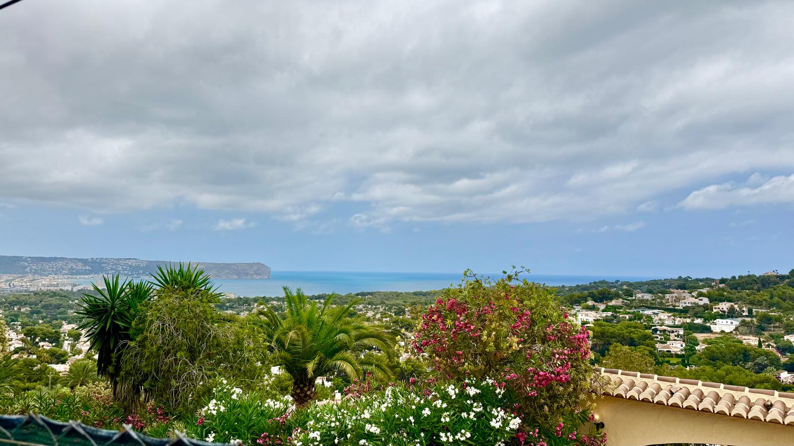 Panoramic views of the Mediterranean Sea and Cabo de San Antonio, framed by mature Mediterranean gardens and lush local flora.