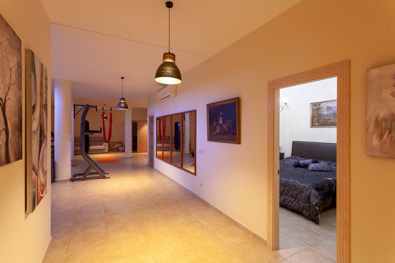 Bright interior featuring a home gym, sauna access, and a bedroom entrance. Note the tiled floor and classic decor.