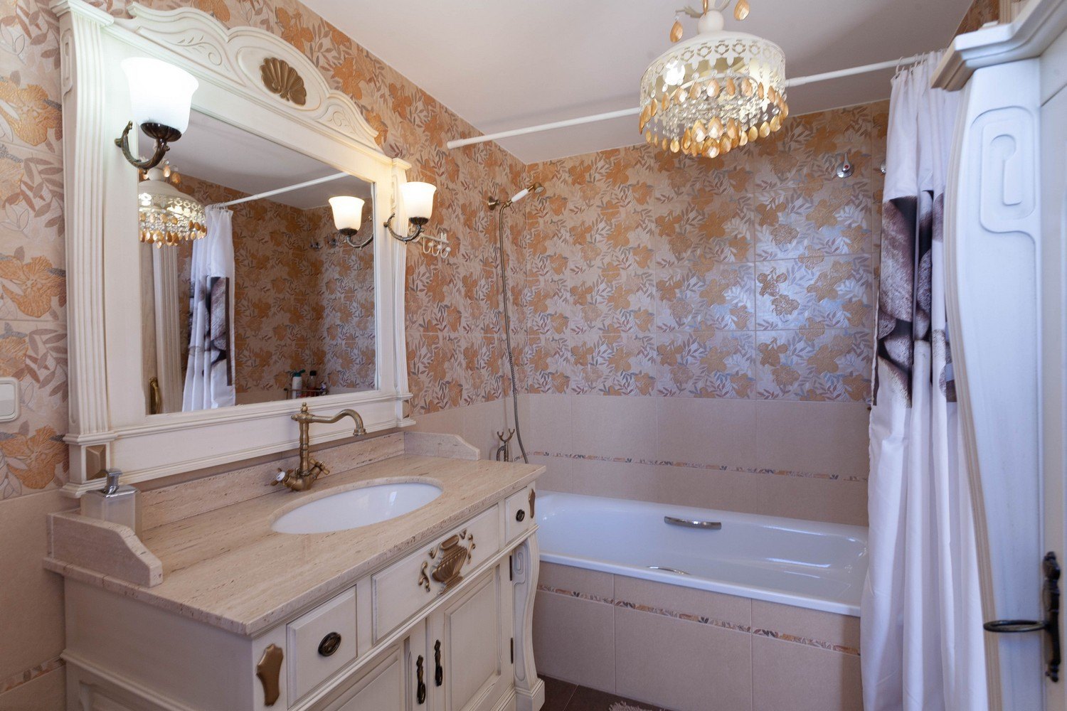 Classic bathroom featuring a marble vanity, ornate mirror, and bathtub with shower.