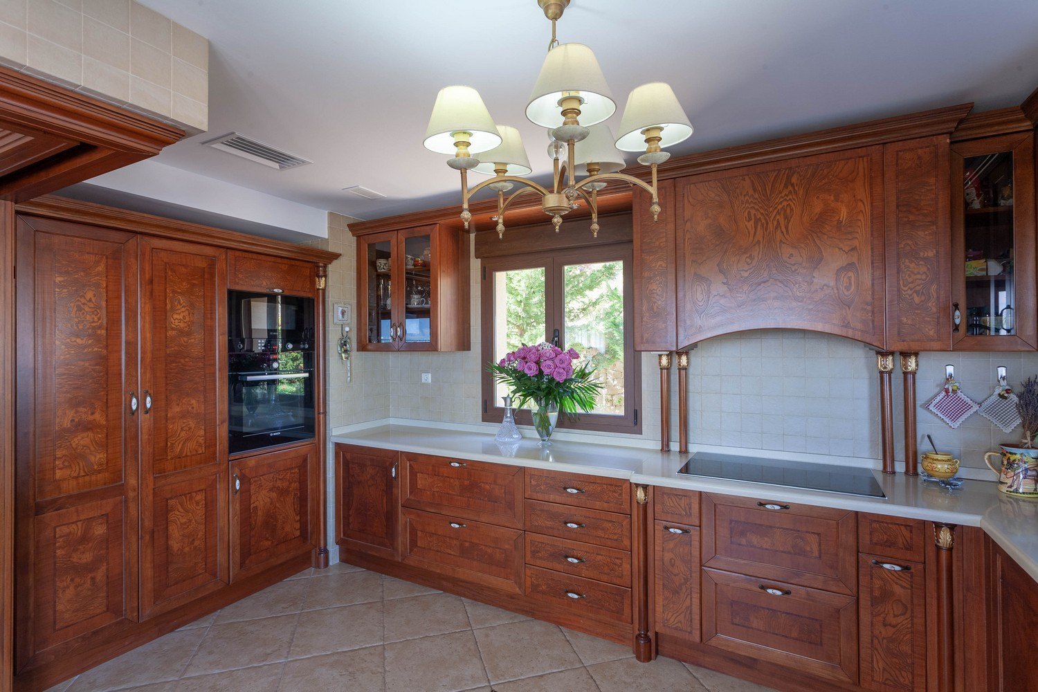 Classic kitchen featuring carved wood cabinetry and white quartz countertops.