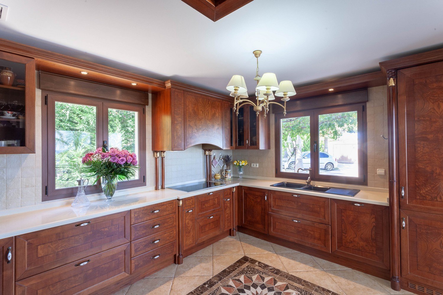 Classic kitchen featuring wood cabinetry, light countertops, and tile flooring with geometric design.
